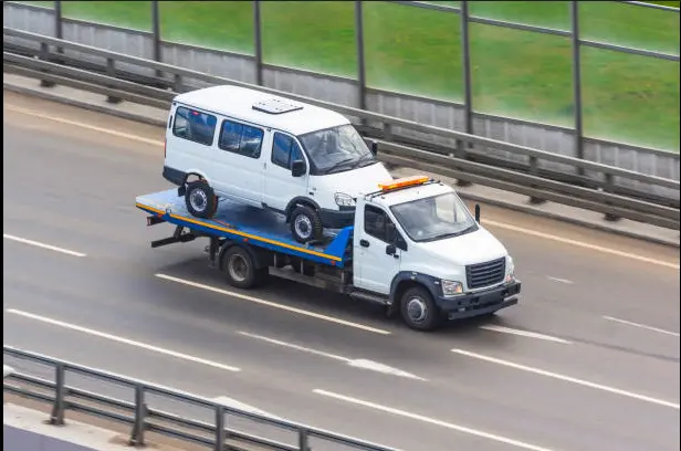 Van being recovered on flatbed truck